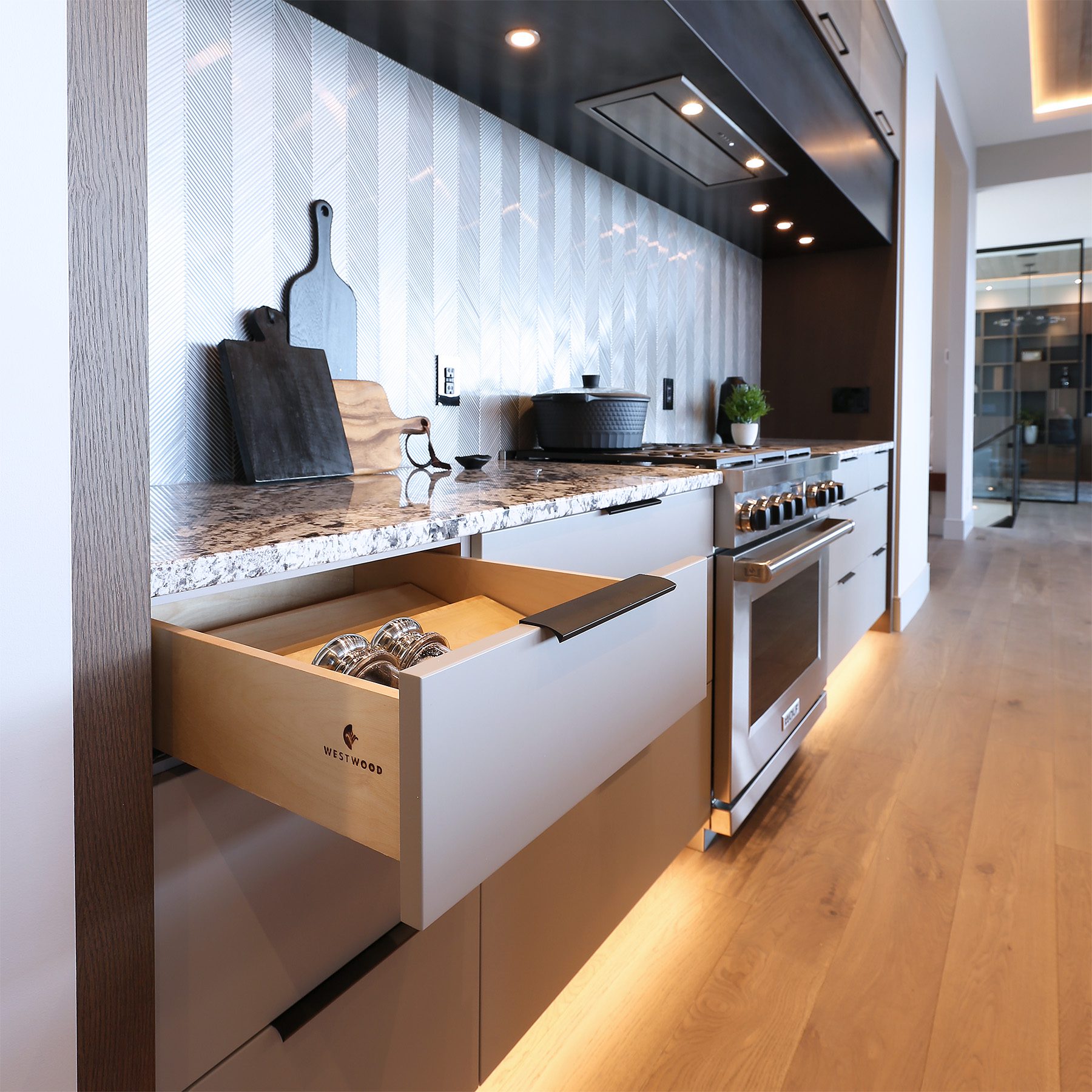 Integrated kitchen storage solution with a hidden coffee station and custom dividers.