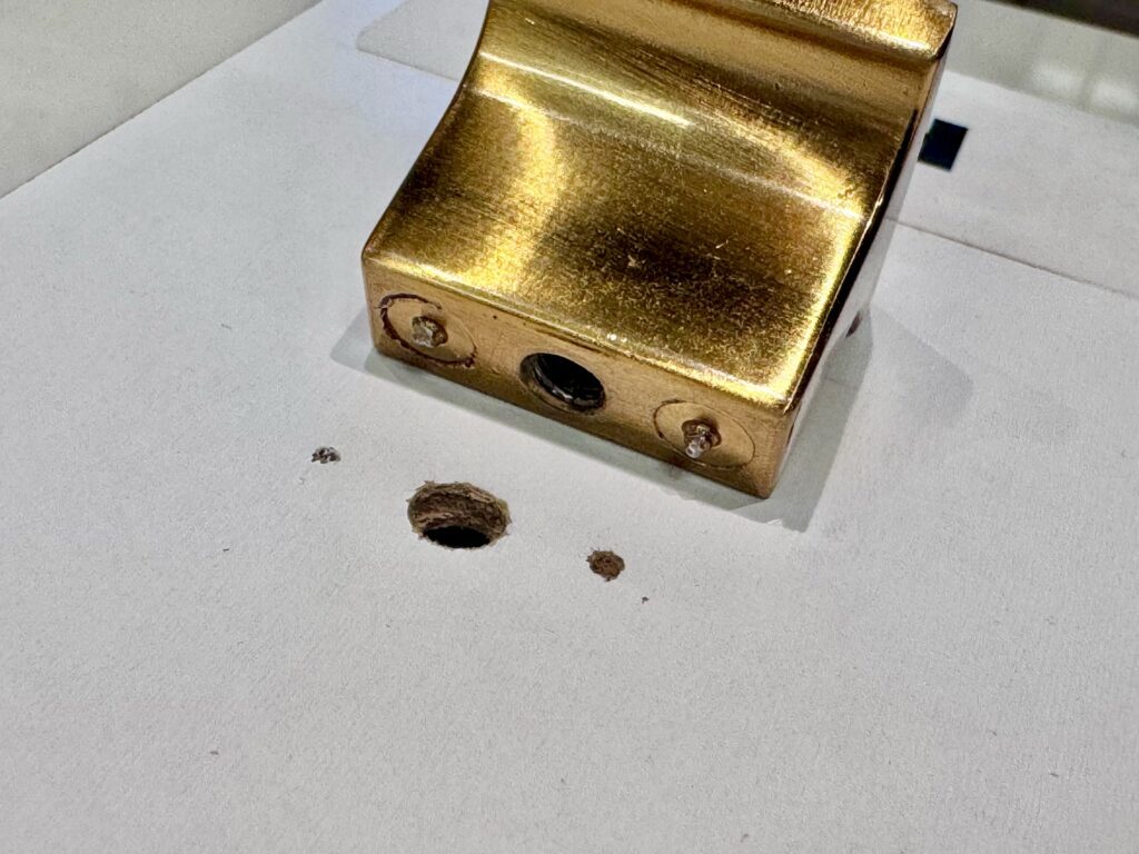 Close-up of indentations in white cabinetry from anti-rotation nibs after cabinet hardware installation.