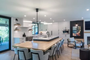 Custom kitchen island featuring a Black Beauty lacquer base and light wood table extension, paired with Chantilly Lace perimeter cabinetry in a modern minimalist home.
